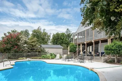 Image de Waterfront home with swimming pool and tennis court.