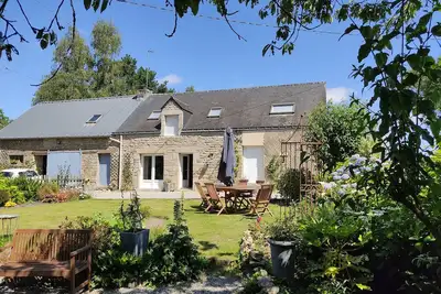Image de Maison de campagne en lisière de forêt avec jardin paysager.