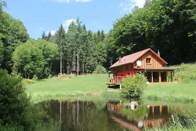 Image de chalet isolé en forêt avec son petit étang privé