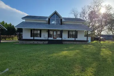 Image de Rocking Chair front porch looking out on sprawling pecan trees filled w/ nature.