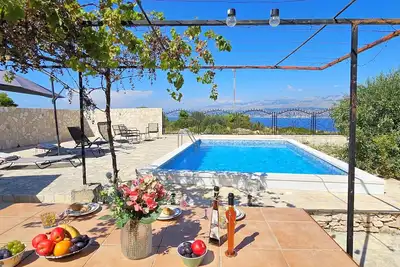 Image de maison en pierre avec piscine, dans un champêtre idyllique, avec vue sur la mer