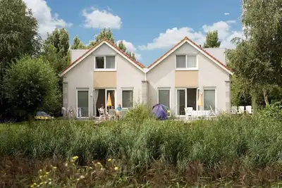 Image de Semi-detached 5-person Schakel Deluxe bungalow with a private sauna, yard, and patio on the waterfront at Beach Resort Makkum on the IJsselmeer.