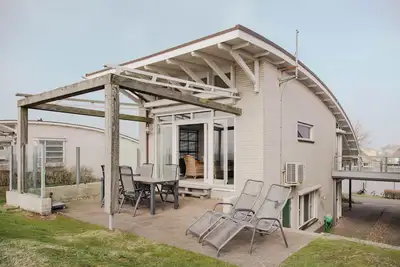 Image de Detached Dijkvilla with a panoramic view of the IJsselmeer, private wellness facilities, and a large patio at the luxurious Beach Resort Makkum.