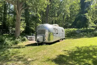 Image de Modern Styled Vintage Airstream Nestled by a Stream on a Picturesque Tree Farm