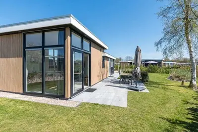 Image de Ce chalet vous accueille avec de hautes fenêtres, un mobilier moderne et une ambiance intérieure agr