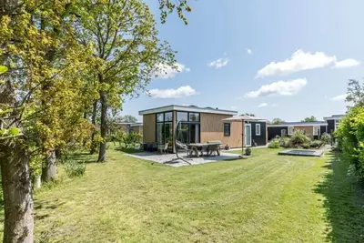 Image de Ce joli chalet est situé dans un endroit magnifique à l'arrière de Schouwenduin, entouré d'un jardin