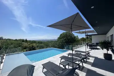Image de Belle villa contemporaine de 2023 avec vue imprenable et piscine à débordement.