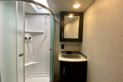 Image de 2 separate Rv’s with queen-sized beds, dining area, and full kitchen.