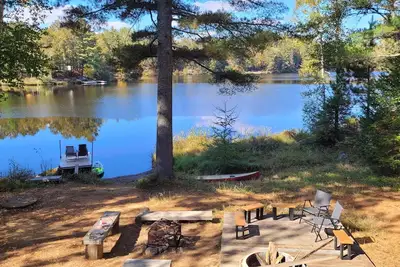Image de Chalet Jaune au Bord du lac Entouré de Pins Blancs